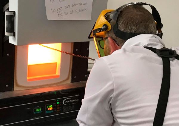John Pearson tests the progress of his glassmaking experiment in our bespoke furnace in the Wolfson Laboratory